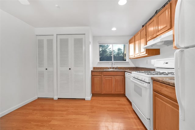 kitchen featuring sink, white appliances, and light wood-type flooring