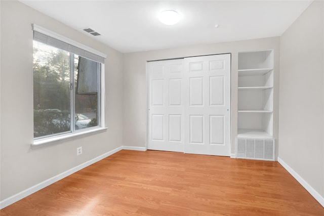 unfurnished bedroom with light hardwood / wood-style floors and a closet