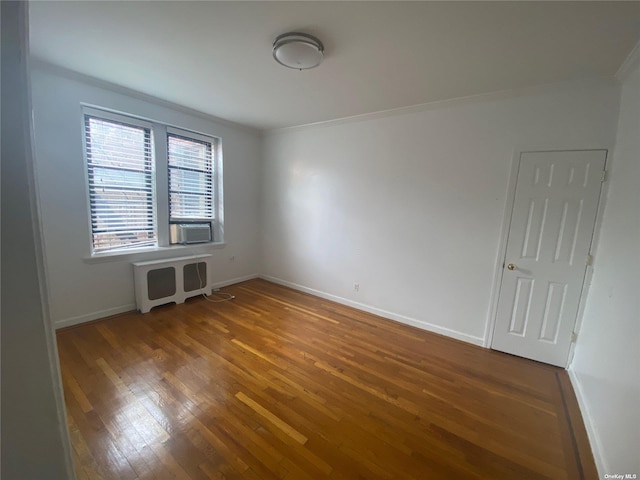 unfurnished room with crown molding, hardwood / wood-style flooring, and radiator heating unit