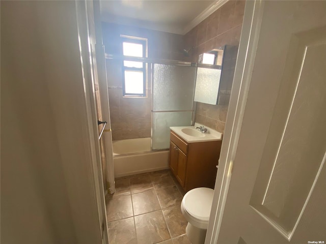 full bathroom with crown molding, combined bath / shower with glass door, vanity, tile patterned floors, and toilet