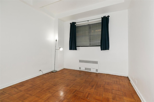 empty room with radiator and parquet floors