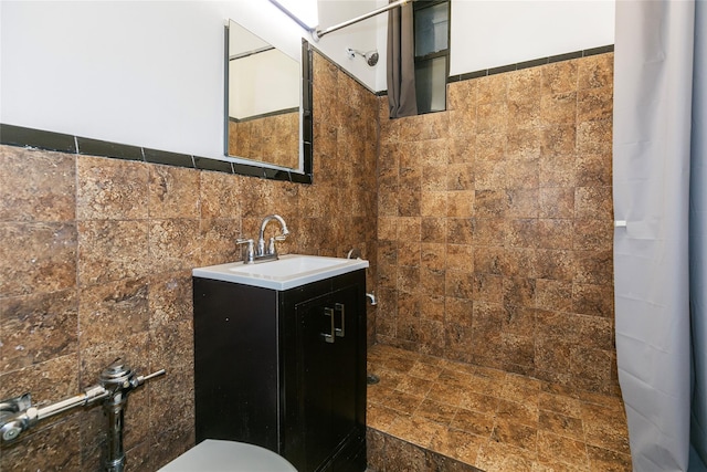 bathroom featuring vanity, tile walls, and a tile shower