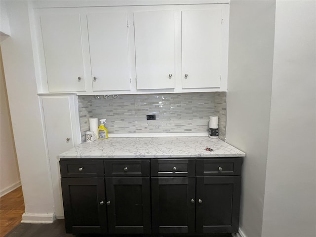 kitchen with white cabinetry, decorative backsplash, and light stone counters