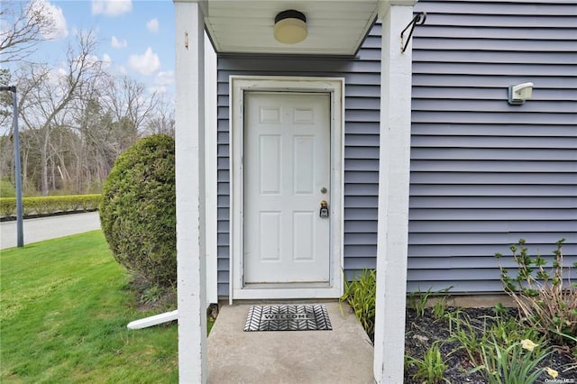 view of exterior entry featuring a lawn