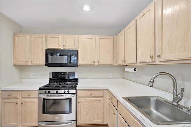 kitchen with a sink, black microwave, stainless steel range with gas stovetop, and light brown cabinetry