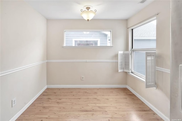 empty room with baseboards and wood finished floors