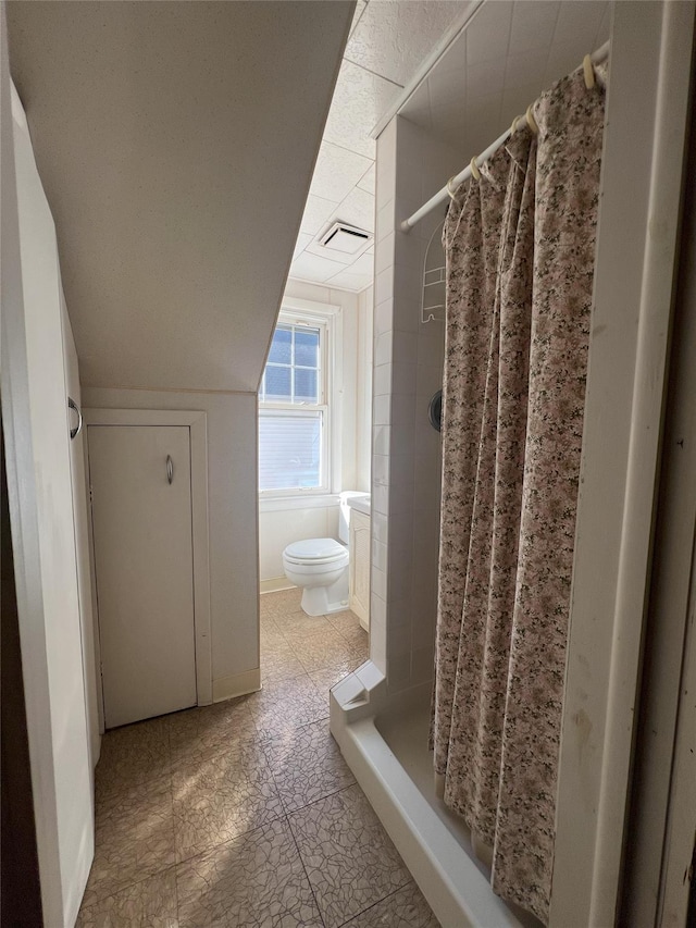 bathroom with curtained shower and toilet