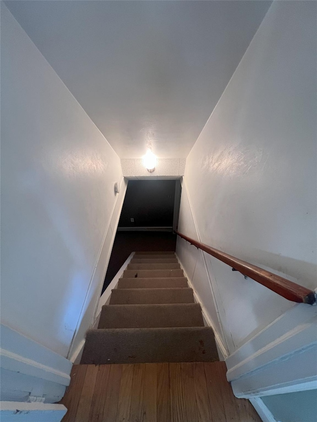 staircase with hardwood / wood-style flooring