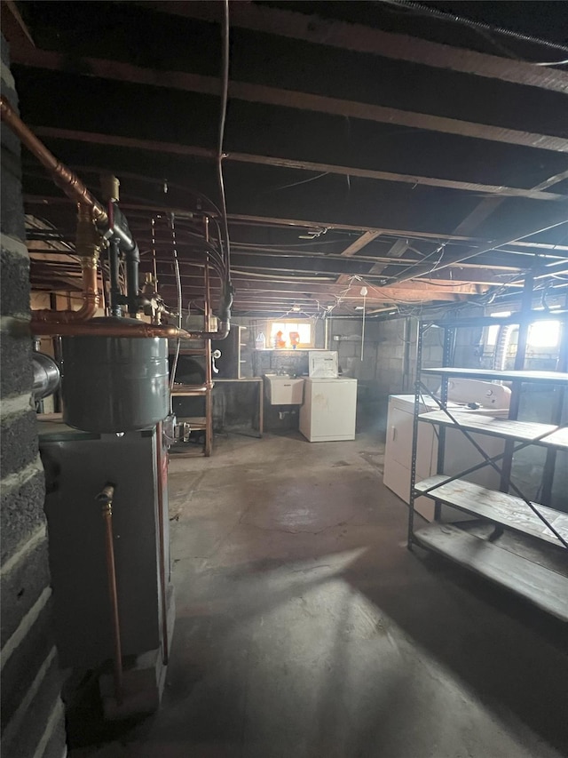 basement featuring independent washer and dryer and sink