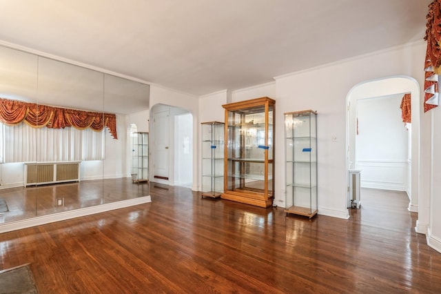 spare room featuring crown molding, radiator, and dark hardwood / wood-style flooring