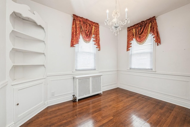 interior space featuring a notable chandelier, dark wood-type flooring, and radiator heating unit