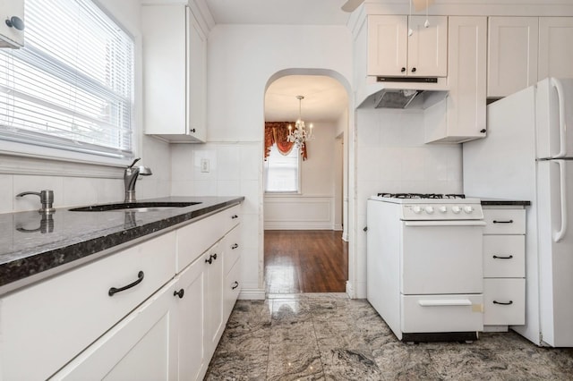 kitchen with sink, backsplash, white cabinets, and white appliances