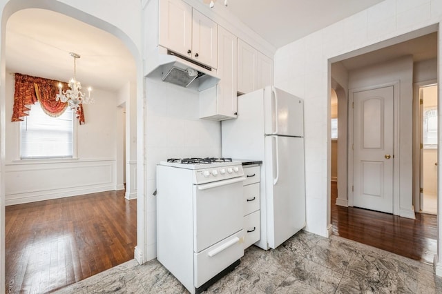 kitchen with white cabinetry, light wood-type flooring, a chandelier, and white appliances