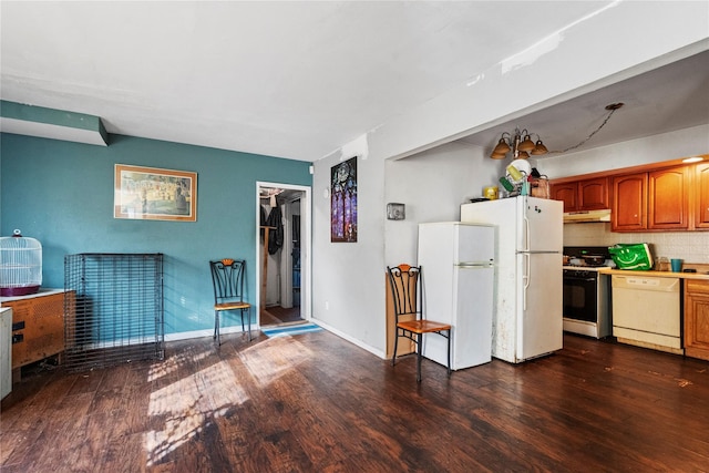 kitchen featuring dark hardwood / wood-style flooring, white appliances, tasteful backsplash, and a notable chandelier