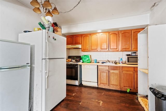 kitchen with tasteful backsplash, sink, dark hardwood / wood-style floors, and white appliances