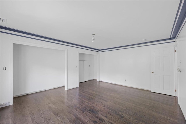 unfurnished room featuring crown molding and dark wood-type flooring