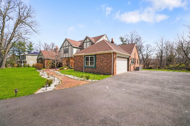 view of front of home featuring a front yard, a garage, and central AC unit