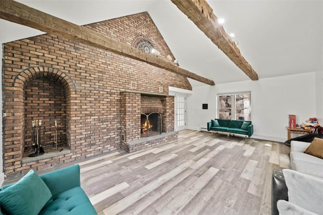 unfurnished living room featuring lofted ceiling with beams, wood-type flooring, a fireplace, and brick wall