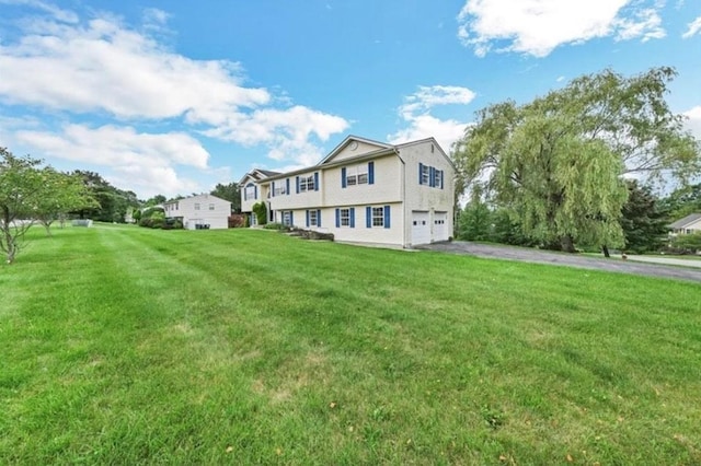 view of front of property featuring a front lawn and a garage