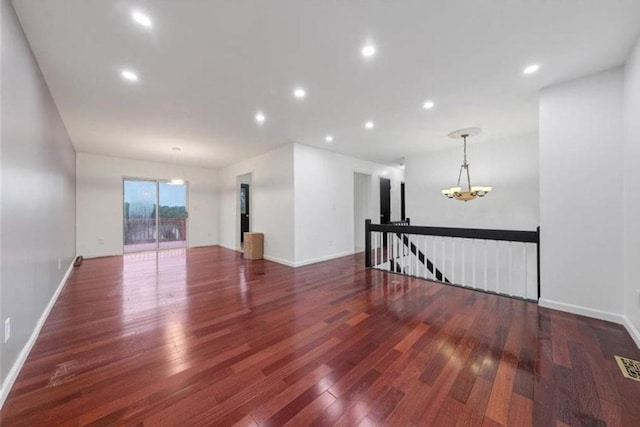 empty room featuring dark hardwood / wood-style floors and an inviting chandelier