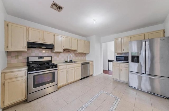 kitchen with tasteful backsplash, sink, light tile patterned floors, and appliances with stainless steel finishes