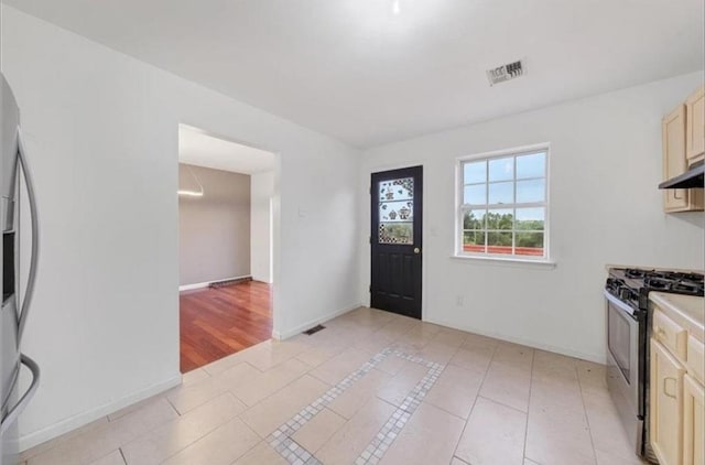 kitchen with appliances with stainless steel finishes, light tile patterned floors, and cream cabinets