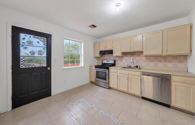 kitchen featuring light tile patterned flooring, sink, stainless steel appliances, and tasteful backsplash