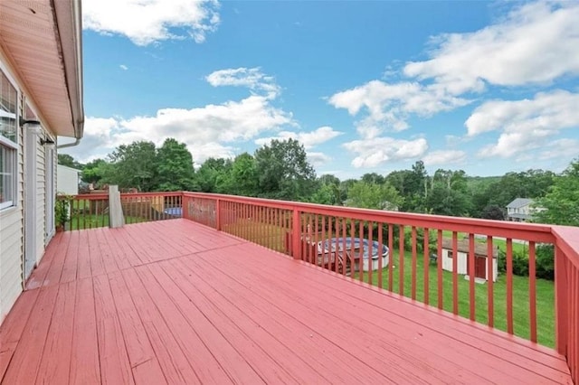 wooden deck with a yard and a storage shed