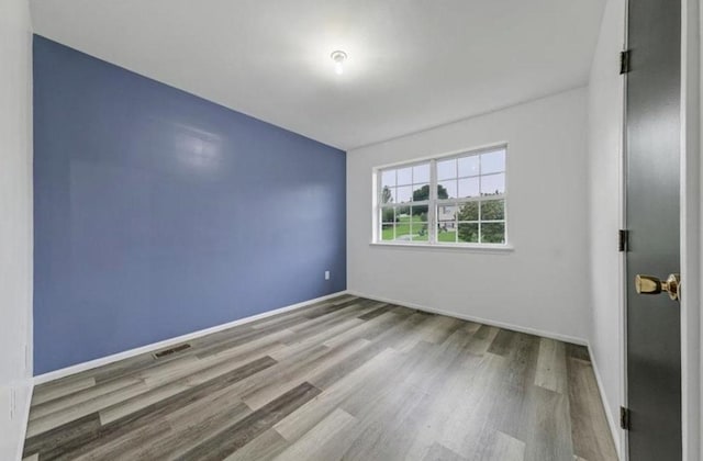 empty room with hardwood / wood-style flooring