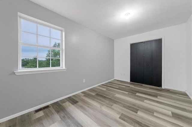 unfurnished bedroom featuring a closet and light hardwood / wood-style floors