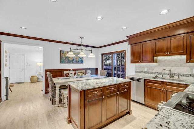 kitchen with dishwasher, light hardwood / wood-style floors, sink, hanging light fixtures, and light stone counters