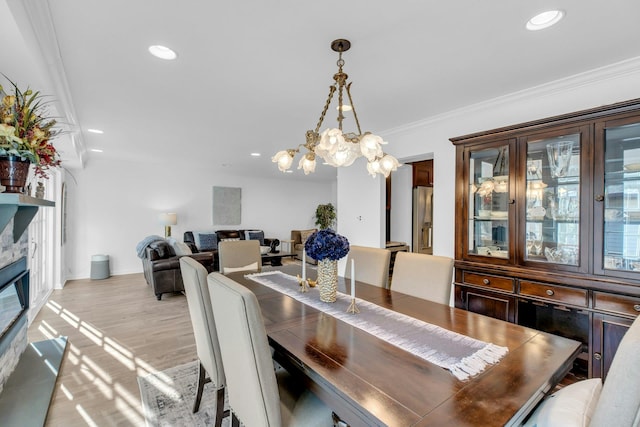 dining space with crown molding and light hardwood / wood-style flooring