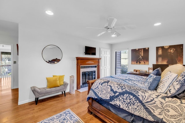 bedroom with ceiling fan, light hardwood / wood-style floors, and multiple windows