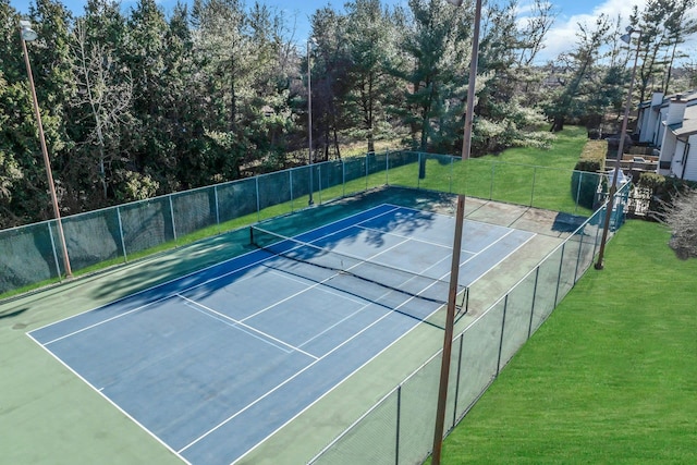 view of sport court with a lawn