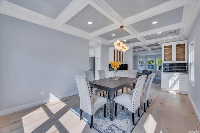 dining area with ornamental molding, coffered ceiling, beam ceiling, light hardwood / wood-style flooring, and a chandelier