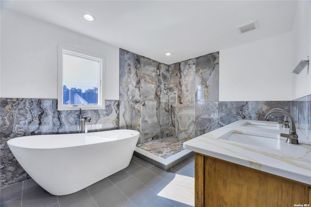 bathroom featuring tile patterned floors, vanity, tile walls, and shower with separate bathtub