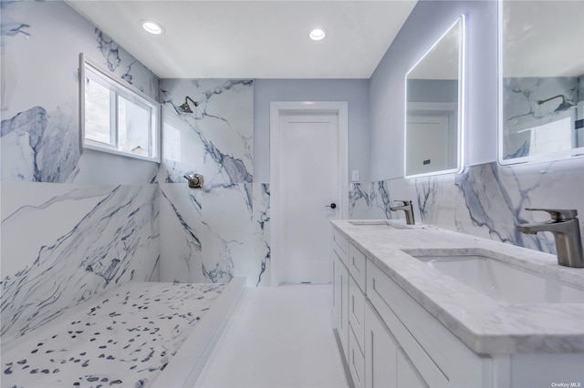 bathroom featuring a shower, vanity, and tile walls