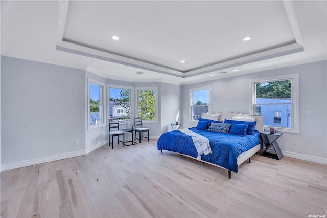 bedroom featuring light hardwood / wood-style floors, a raised ceiling, and crown molding