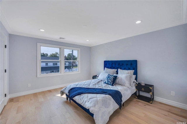 bedroom with light wood-type flooring and ornamental molding