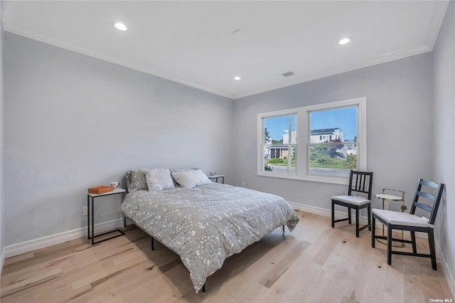 bedroom with light wood-type flooring and crown molding