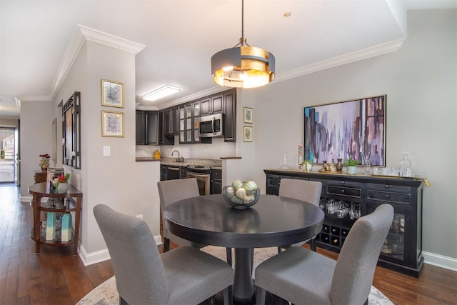 dining space with crown molding, dark wood-type flooring, and sink