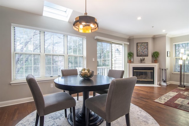 dining room with ornamental molding, dark hardwood / wood-style flooring, and a skylight