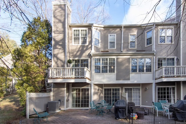 back of house with cooling unit, a patio area, and a balcony