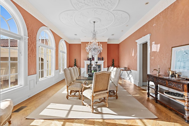 dining area with light parquet flooring, a notable chandelier, and ornamental molding