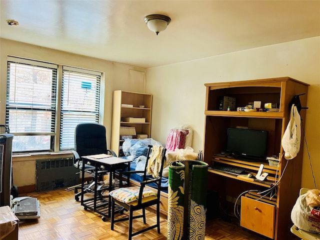 home office featuring radiator, a wealth of natural light, and light parquet flooring