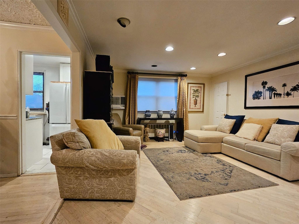 living room featuring light wood-type flooring and ornamental molding