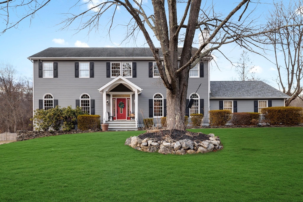 colonial house featuring a front lawn