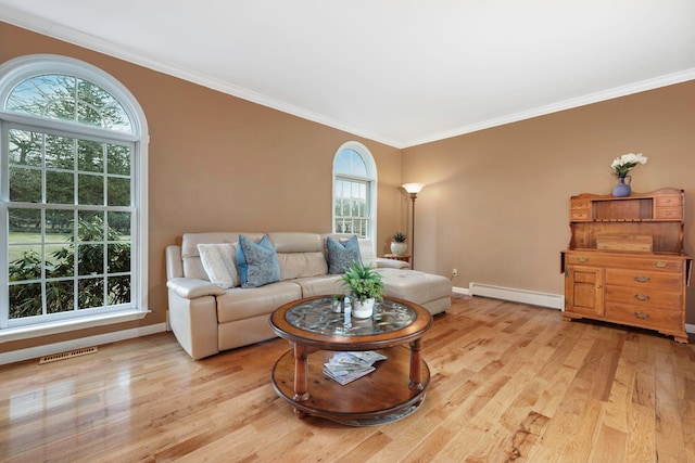 living room with ornamental molding, a baseboard heating unit, and light hardwood / wood-style flooring