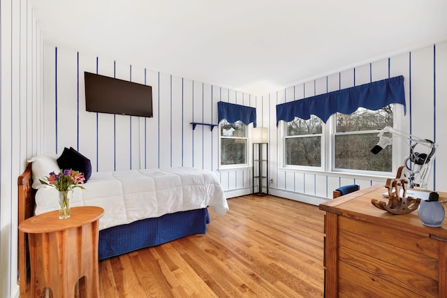 bedroom with wood-type flooring and wood walls