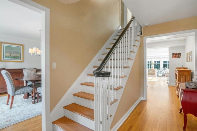 stairs with a chandelier and hardwood / wood-style floors